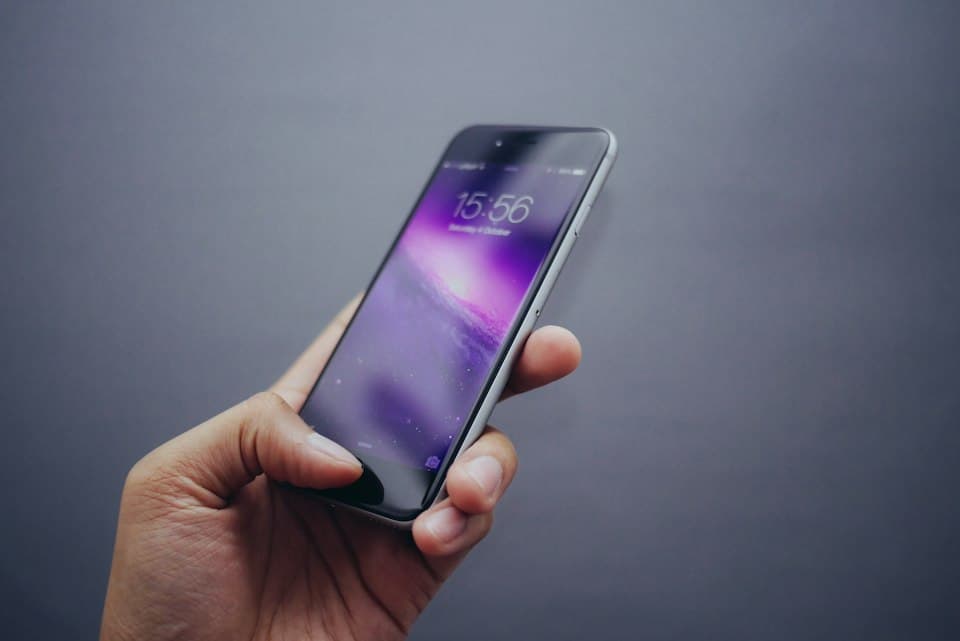 Smartphone in der Hand mit eingeschaltetem Bildschirm
