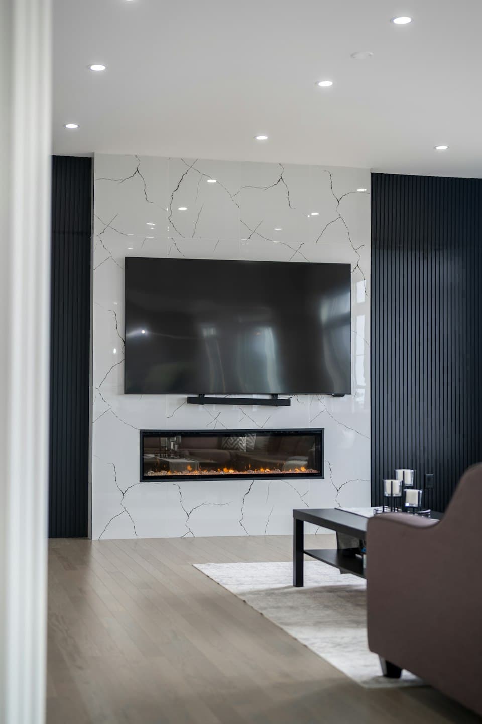 Modernes Wohnzimmer mit großem Wandfernseher über einem Kamin